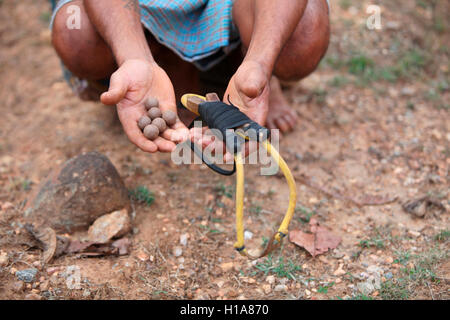 L'homme tribal avec catapulte et pierres, boue, tribu muria benur village, chattisgarh, Inde Banque D'Images