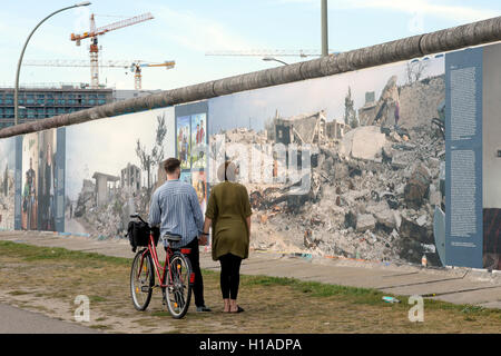 Berlin, Allemagne. 22 Sep, 2016. Les touristes regarder des photos par Kai Wiedenhoefer, placé sur le côté arrière de la East Side Gallery à Berlin, Allemagne, 22 septembre 2016. Le monument est en cours de rénovation et de nettoyage. Photo : MAURIZIO GAMBARINI/dpa/Alamy Live News Banque D'Images