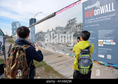 Berlin, Allemagne. 22 Sep, 2016. Les touristes prennent des photos de l'enceinte clôturée East Side Gallery à Berlin, Allemagne, 22 septembre 2016. Le monument est en train d'être nettoyée et restaurée. PHOTO : MAURIZIO GAMBARINI/dpa/Alamy Live News Banque D'Images