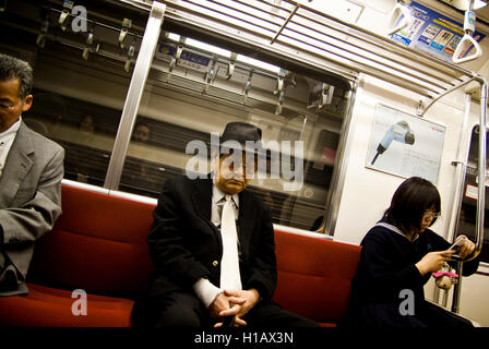 Un homme dort dans le métro de Tokyo, Japon Banque D'Images