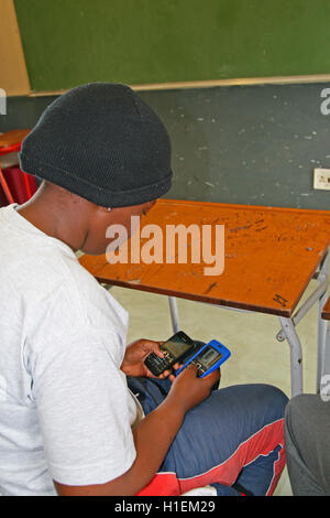 Fille de l'école sur son portable en classe, St Mark's School, Mbabane, Hhohho, Royaume du Swaziland Banque D'Images