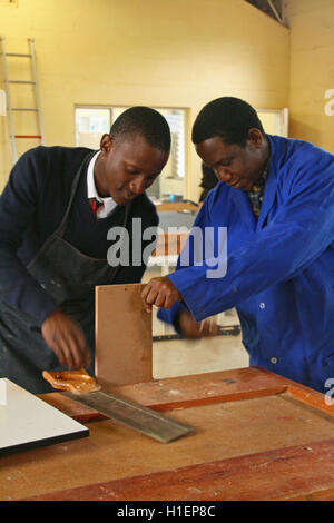 Garçon de l'école en bois de serrage avec l'enseignant en classe de menuiserie, St Mark's School, Mbabane, Hhohho, Royaume du Swaziland Banque D'Images