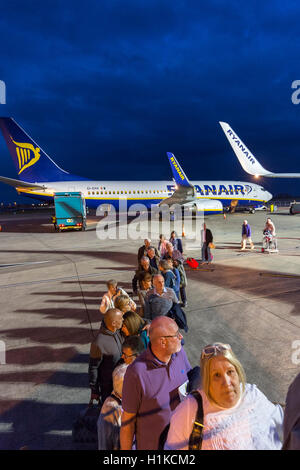 Les passagers d'un vol Ryanair à l'aube, l'aéroport de Bristol, Angleterre, Royaume-Uni Banque D'Images