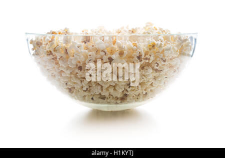 Popcorn salé savoureux en grand bol en verre isolé sur fond blanc. Banque D'Images