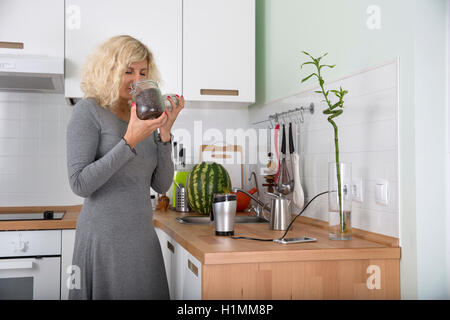 Fille blonde avec les cheveux bouclés est odeur de café en grains Banque D'Images