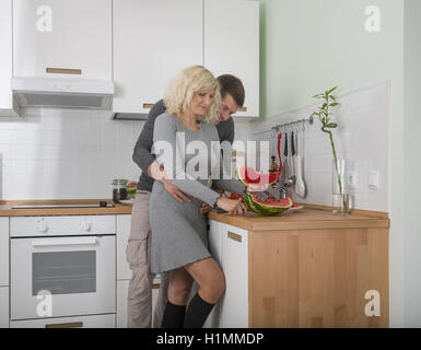 Beautiful couple mange wateremelon sur la cuisine Banque D'Images