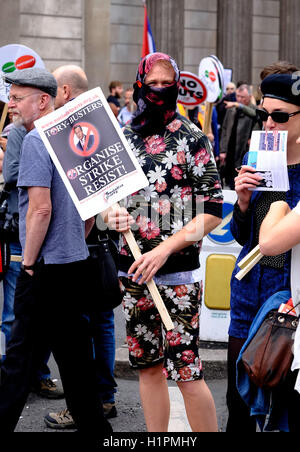 Manifestant un homme avec son visage est caché holding a placard et vêtus de vêtements avec des fleurs sur Banque D'Images