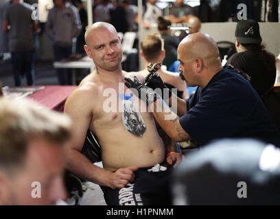 Un homme d'avoir un tatouage fait au cours de la London International Tattoo Convention au quai du tabac à Londres. Banque D'Images