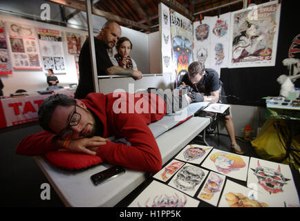 Un homme d'avoir un tatouage fait au cours de la London International Tattoo Convention au quai du tabac à Londres. Banque D'Images