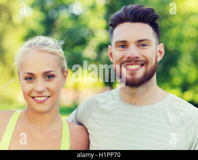 Heureux les amis ou les sportifs couple hugging outdoors Banque D'Images