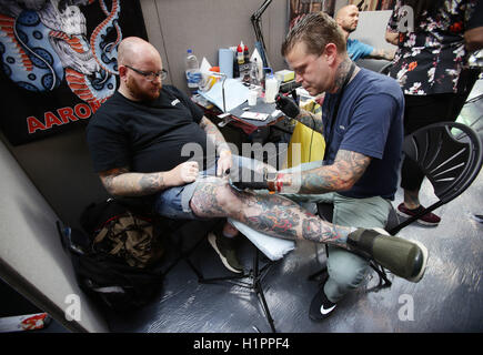 Un homme d'avoir un tatouage fait au cours de la London International Tattoo Convention au quai du tabac à Londres. Banque D'Images