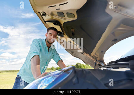 Homme à ouvrir le capot de voiture à la campagne Banque D'Images