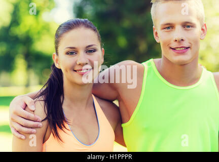 Heureux les amis ou les sportifs couple hugging outdoors Banque D'Images