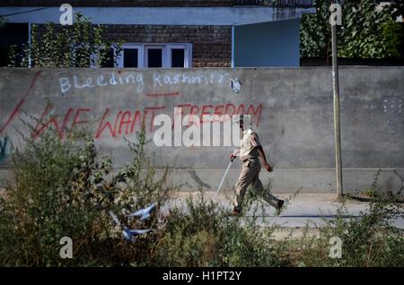 Cachemire, Inde. 29Th Sep 2016. Un policier indien passe devant un graffiti de Srinagar, la capitale d'été du Cachemire sous contrôle indien. La sécurité a été renforcé à travers la vallée du Cachemire après militants présumés ont attaqué la base de l'armée indienne dans le nord du Cachemire sur Uri dans laquelle 18 soldats de l'armée indienne et quatre militants présumés ont été tués . Credit : Faisal Khan/Pacific Press/Alamy Live News Banque D'Images