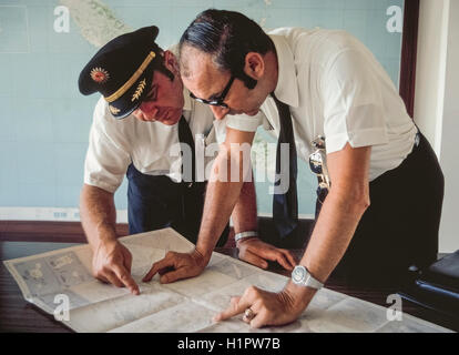 Le Capitaine Ross Zimmerman et copilote James McKenna étudier une carte avant de s'engager avec leurs jet Convair 990 de voler une charte du transport aérien moderne appelé 'Oiseaux polaires II.' l'avion transportait 48 passagers par le Pôle Nord et le Pôle Sud sur un unique 32 jours autour du monde organisé par Hemphill Monde Croisières Air de Los Angeles, Californie, pour le siècle des Voyageurs Club. C'était la plus chère de l'époque de la tournée mondiale (1970) à 9 760 $ par personne. Banque D'Images