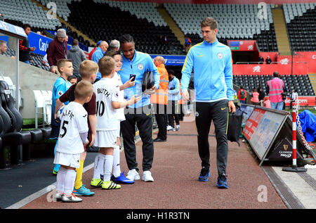 Manchester City's Raheem Sterling et Jean Pierre (à droite) avec les mascottes de match avant la Premier League match au Liberty Stadium, Swansea. Banque D'Images