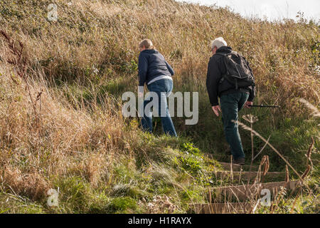 Mâles et femelles matures les randonneurs l'ascension de la pente raide sur le Cleveland Way à Saltburn by the Sea Banque D'Images