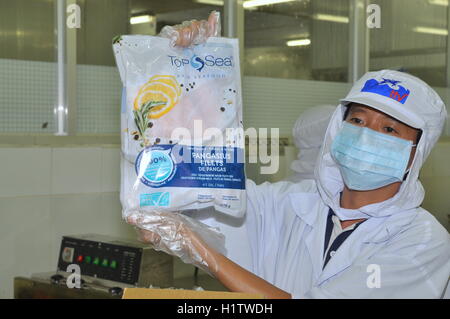 La province de Tien Giang, Vietnam - 2 mars 2013 : un travailleur est montrant un poisson pangasius certifié produit dans une usine de transformation de fruits en Tie Banque D'Images