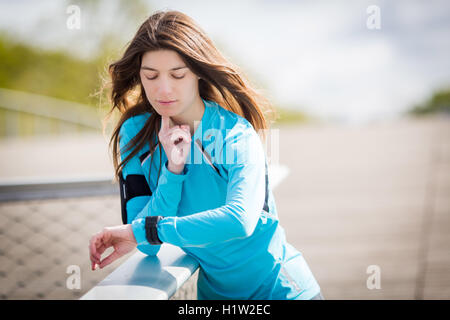 Femme contrôle son pouls après l'exercice. Banque D'Images