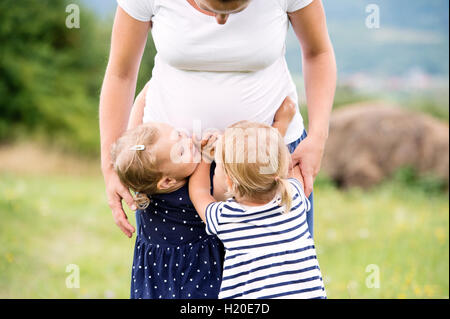 Femme enceinte au parc avec des petites filles Banque D'Images