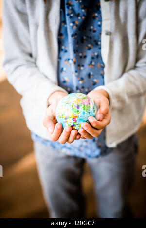 Fille de 9 ans tenant un globe dans ses mains. Banque D'Images