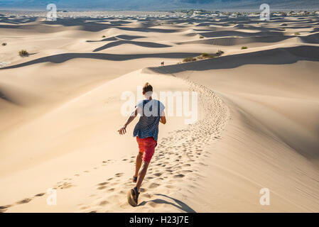 Jeune homme, touristiques sur dune de sable, Mesquite dunes de sable plat, la vallée de la mort, Death Valley National Park, California, USA Banque D'Images