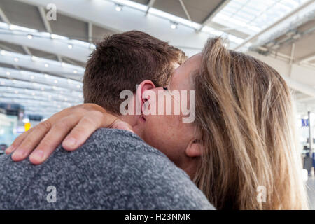 Un jeune homme dit au revoir à sa mère pour aller en voyage, l'aéroport de Heathrow, Royaume-Uni Banque D'Images