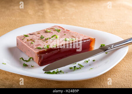 Le pâté de foie sur plaque de porc et de viande de cerf sur plaque blanche avec couteau de cuisine Banque D'Images