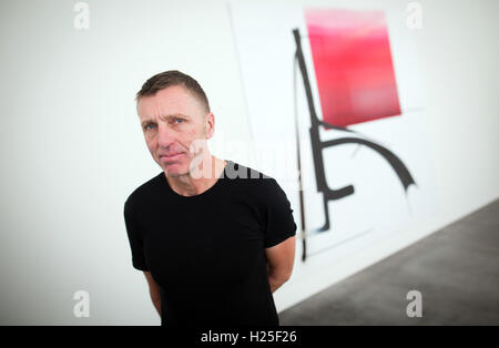 Reutlingen, Allemagne. 25 Septembre, 2016. Artiste Albert Oehlen debout devant une de ses toiles lors de l'ouverture de l'exposition de l'artiste Georg Baselitz et Albert Oehlen à Reutlingen, Allemagne, 25 septembre 2016. L'exposition est ouverte jusqu'au 15 janvier 2017. PHOTO : CHRISTOPH SCHMIDT/dpa/Alamy Live News Banque D'Images