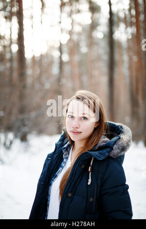 Jeune femme élégante dans des vêtements d'hiver en hiver permanent de la forêt. Paysage de forêt d'hiver sur l'arrière-plan. Banque D'Images