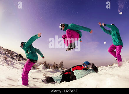 Snowboarder saute par skieur sur fond de basses montagnes Banque D'Images