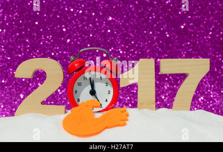 Bonne année 2017 carte de vœux. Réveil et les chiffres 2017 dans un banc de neige sur un arrière-plan transparent bleu Banque D'Images
