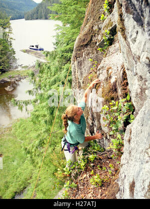 Un invité à Nimmo Bay Resort rock grimpe sur un mur à l'extrémité est de peu de Nimmo Bay. British Columbia, Canada Banque D'Images