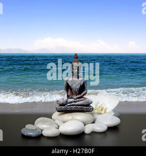 Bouddha zen stone,blanc,fleurs d'orchidées et le fond de ciel Banque D'Images