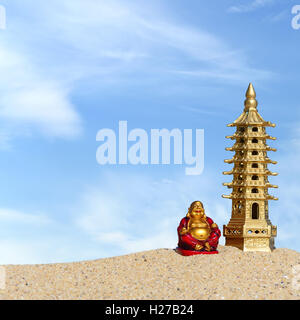 Laughing Buddha et pagode de 7 étages dans le sable. Symbole de chance et de la prospérité dans le Feng-Shui Banque D'Images