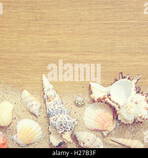 De sable, de coquillages et d'étoiles sur un fond de bois. Photo en style vintage Banque D'Images