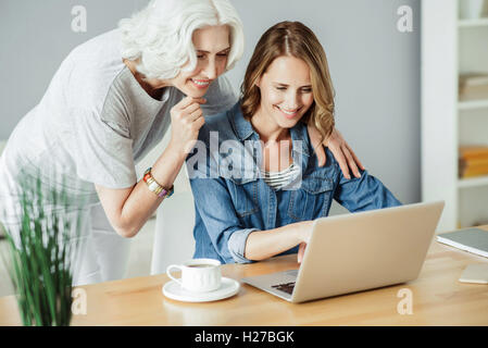 Femme joyeuse using laptop Banque D'Images