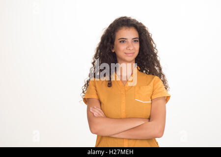 Belle jeune femme avec des cheveux bouclés bras croisés à la voiture en souriant sur un fond blanc. Banque D'Images