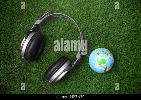 Globe terrestre et casque sur une herbe Banque D'Images