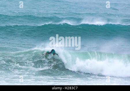 Dans de grandes coupes surfer dans des vagues propres Cornwall Polzeath Banque D'Images