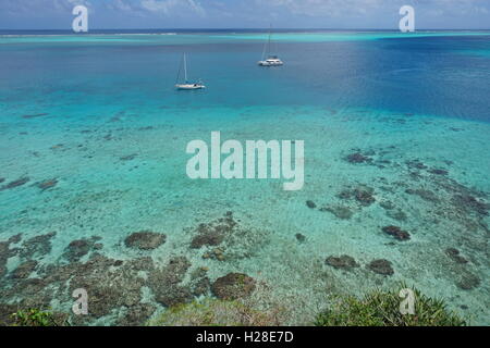 Vue aérienne sur le lagon avec deux bateaux ancrés, l'océan Pacifique Sud, l'île de Huahine, Polynésie Française Banque D'Images