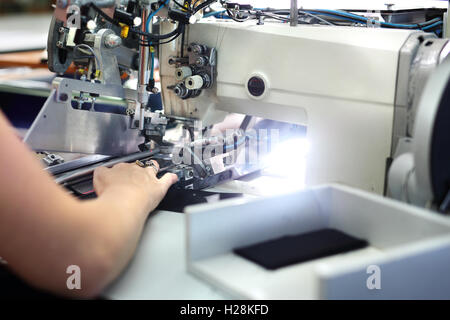 La production de vêtements, sur une machine à coudre Overlock. Banque D'Images