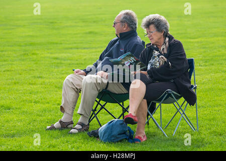 Couple à la recherche de programme à en l'air, une partie de l'intérieur vers l'extérieur au projet, Harbourside, popularité des chaussures élégantes Park, Poole Banque D'Images