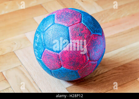 Bleu et rouge sale ball Handball sur un parquet en bois Banque D'Images