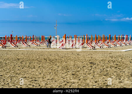 Orange vide chaises longues et parasols sur la plage, au début de saison, Viareggio, Toscane, Italie Banque D'Images