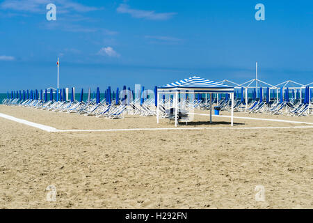 Bleu vide chaises longues et parasols sur la plage, au début de saison, Viareggio, Toscane, Italie Banque D'Images