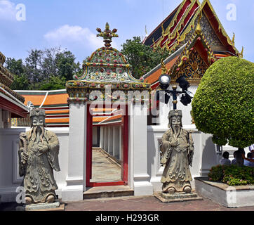 Temple de Wat Pho à Bangkok, Thaïlande, avec ses stupas et ses flèches, et les passerelles, avec statue gardes. Banque D'Images