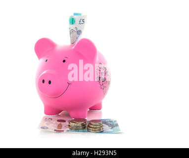 Pink Piggy Bank avec de nouveaux billets et pièces cinq livres (un fond blanc Banque D'Images