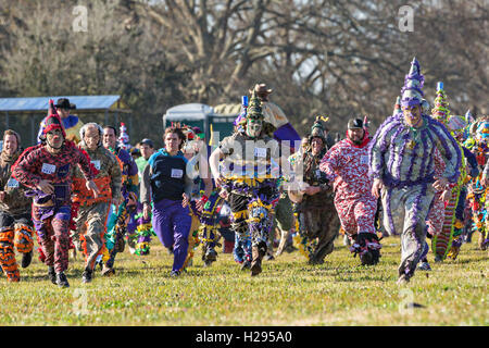 Mardi Gras Cajun fêtards s'exécuter après avoir atteint une maison de ferme au cours de la Church Point Courir de Mardi Gras Le 7 février 2016 à Church Point, en Louisiane. Par le Cajun Ramblers romp méfait causant des prairies et la mendicité puis célébrer par la danse. Banque D'Images