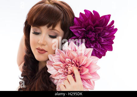 Brunette Auburn english rose portrait féminin vêtu de blanc avec d'énormes fleurs violet et rose Banque D'Images